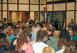 Teenagers from across the archdiocese come together in a moment of reverent silence before a crucifix during the “ArchIndy Teen Experience” at Butler University in Indianapolis on Nov. 4. (Photo by John Shaughnessy)