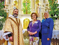 Father Aaron Pfaff, then-pastor of St. Joseph Parish in Shelbyville, poses with newly confirmed Catholic Edy Ballard, center, and her sponsor, Carol McElroy, in St. Joseph Church after the parish’s Easter Vigil Mass on March 26, 2016. Returning to the Church after being away for 40 years, Edy Ballard of St. Joseph Parish in Shelbyville became involved in starting evangelization outreach efforts for her faith community. (Submitted photo)
