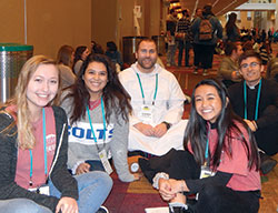 Dominican Father Patrick Hyde, associate pastor of St. Paul Catholic Center in Bloomington and head of the parish’s campus ministry serving the students of Indiana University (IU), center, enjoys a break on Jan. 5 with IU students Jenna Fisher, Rachel Folstrom and Arianna Dacanay during SEEK2019 at the Indiana Convention Center in Indianapolis. Also pictured at right is Thomas Leah, a seminarian for the Archdiocese of Chicago. (Photo by Mike Krokos)