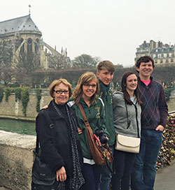With Notre Dame Cathedral in the background, Aline Cambon poses with her students Caroline Wehner, second from left, Skip Maas, Hannah Storm and Myles Hesse during a trip she led to France. Cambone has been a French teacher at her alma mater, Father Michael Shawe Memorial Jr./Sr. High School in Madison, for 40 years. (Submitted photo)