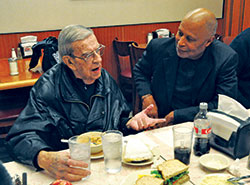 John Welch, left, and David Shaheed share a conversation during a lunch on Jan. 11 at Shapiro’s Delicatessen in Indianapolis. In 1997, Welch, a longtime member of St. Joan of Arc Parish in Indianapolis and Focolare, a Catholic lay movement, started sharing lunch with members of the Nur‑Allah Islamic Center in Indianapolis, including Shaheed. Over the years, the lunch has grown to include other Focolare members and Protestant clergy. (Photo by Sean Gallagher)