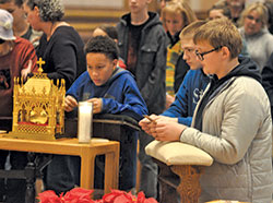 Johnny Volk, left, Abraham Hudepohl and Dominic Martini, all eighth-grade students at St. Nicholas School in Ripley County, pray before the incorrupt heart of St. John Vianney on Jan. 4 in SS. Peter and Paul Cathedral in Indianapolis. The relic will be available for veneration on March 12 at St. Paul Church in Tell City. (File photo by Sean Gallagher)