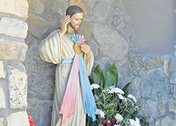 A hand-carved statue made in Italy is the focal point of the Divine Mercy grotto at Prince of Peace Parish in Madison. (File photo by Natalie Hoefer)