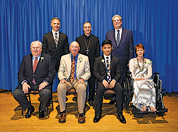 Catholic Charities Indianapolis presented four individuals with Spirit of Service Awards during an April 24 dinner in Indianapolis. Award recipients, seated from left, are Michael Isakson, Rita Kriech, Paul Hnin and Dr. Michael Patchner. Standing, from left, are David Bethuram, executive director of the archdiocese’s Catholic Charities, Archbishop Charles C. Thompson and keynote speaker Joe Reitz. (Submitted photo by Rich Clark)