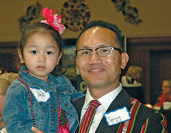 Joshua Hlawnmual holds his daughter Irene during the celebration of World Refugee Day on June 20 at the Archbishop Edward T. O’Meara Catholic Center. Hlawnmual, a refugee who fled Burma (now Myanmar) in 2010, now helps other refugees as a case manager for the archdiocese’s Refugee and Immigration Services. (Photo by John Shaughnessy)