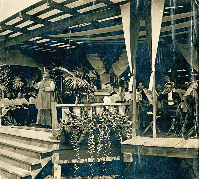 This photo features Bishop Joseph Chartrand preaching at the dedication of a new Knights of Columbus building at Fort Benjamin Harrison in Indianapolis on July 21, 1918. With his elbow on the railing is Father Joseph E. Ritter, who later became the first archbishop of Indianapolis, and then a cardinal.