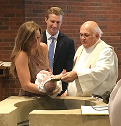 Father Jerry Kirkhoff baptizes his great-great niece, Grace Kirkhoff, while her godparents—Maryann Kirkhoff and Michael Bower—take part in the sacrament at St. Barnabas Church in Indianapolis on Aug. 18, 2018. (Submitted photo)