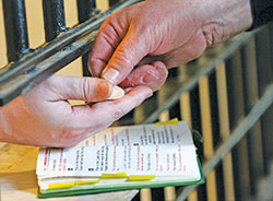 A chaplain distributes Communion to a death-row inmate at Indiana State Prison in Michigan City, Ind. The U.S. Department of Justice on July 25 announced that it is reinstating the federal death penalty, with five executions scheduled to take place at the U.S. Penitentiary in Terre Haute in December and January. (CNS file photo/Karen Callaway, Northwest Indiana Catholic)