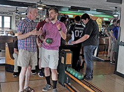 Archdiocesan seminarians John Geis, left, and Charlie Wessel share strategies during a duckpin bowling session on Aug. 6 at Action Duckpin Bowl in Indianapolis. The bowling session was part of the annual convocation for archdiocesan seminarians. (Photo by Sean Gallagher)