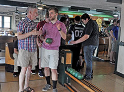 Archdiocesan seminarians John Geis, left, and Charlie Wessel share strategies during a duckpin bowling session on Aug. 6 at Action Duckpin Bowl in Indianapolis. The bowling session was part of the annual convocation for archdiocesan seminarians. (Photo by Sean Gallagher)