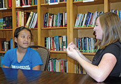 As a volunteer sign language interpreter for St. Pius X Parish in Indianapolis, Stephanie Campo translates God’s message to 12-year-old parishioner Bae Meh, who is deaf. (Photo by John Shaughnessy)