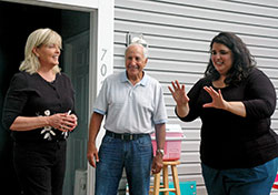 Alma Figueroa, right, shares her plans for the backyard of her family’s home with Suzanne Thompson, executive director of Hearts & Hands of Indiana, and Paul Corsaro, one of the founding members of the organization dedicated to giving hope and houses to low-income families on the near-west side of Indianapolis. (Photo by John Shaughnessy)