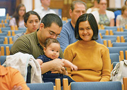 Jose and Nuri Ordaz, members of St. John the Evangelist Parish in Indianapolis, dote on their 5-month-old son Joshua during the Respect Life Mass at SS. Peter and Paul Cathedral in Indianapolis on Oct. 6. (Photo by Natalie Hoefer)