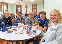 Franciscan Sister Kathleen Branham, center, smiles with her “adopted” students in the lunchroom at the motherhouse of the Sisters of St. Francis of Oldenburg in Oldenburg on Oct. 9. The sisters invite students from the Oldenburg Academy of the Immaculate Conception to eat lunch together twice a month. The students are, from left, Kate Walke, Emerald Simmonds, Lleyton Knecht and Kate Voegele. (Photo by Katie Rutter)