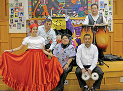 Musicians and a dancer of the Indy Peruvian Incan Cultural Association (IPICA) pose for a photo after providing entertainment at a reception on Nov. 3 in the St. Monica School cafeteria after a Mass celebrating the feast of St. Martin de Porres, who was born and raised in Peru. They are IPICA dancer Andrea Capunay, left, Jaime Torpoco of St. Susanna Parish in Plainfield, IPICA founder Patricia Meneses, David Sierra of Holy Spirit Parish in Indianapolis, and Angel Hurtado of St. Monica Parish. (Photo by Natalie Hoefer)