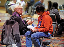 Father Carlton Beever speaks on Nov. 22 in the Indiana Convention Center in Indianapolis with a National Catholic Youth Conference participant during a celebration of the sacrament of penance. Father Beever is pastor of St. Mary Parish in Indianapolis. (Photo by Sean Gallagher)