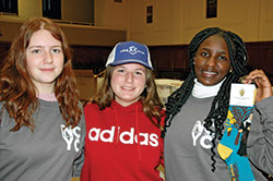 Grace Swinefurth, left, Alyssa Struewing and Joan Njoroge show off part of the ensemble that youths from the Archdiocese of Indianapolis were given to sport during the National Catholic Youth Conference. (Photo by John Shaughnessy)