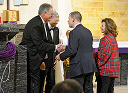 Outgoing Indianapolis Legatus chapter president Jim Huntington, left, shakes hands with newly inducted members Dave and Victoria Temple during Mass at St. Michael the Archangel Church in Indianapolis on Dec. 12, 2019. To Huntington’s right is Legatus founder Tom Monaghan. (Photo by Natalie Hoefer)