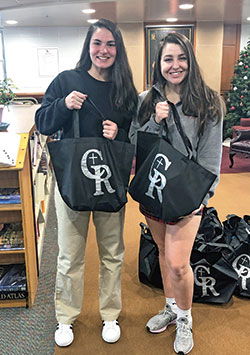 Gabriella Hicks, left, and Chloe Olejnik, both seniors at Cardinal Ritter Jr./Sr. High School in Indianapolis, hold bags that they and fellow students filled with food for students in need in Catholic schools in the Indianapolis West Deanery. The student-driven “Backpack Blessings” program is in its second year and provides food for 150 students in the West Deanery during three breaks in the academic year. (Submitted photo)