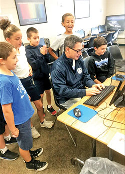 Principal Rob Detzel is completely focused as he participates in a fun typing competition with fourth-grade students at St. Lawrence School in Lawrenceburg. (Submitted photo)