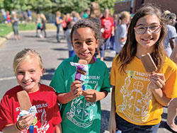 St. Thomas Aquinas School students Emmerson Bloede, left, Lauryn Klitzman and Genevieve Maminta celebrate with ice cream treats after their Indianapolis North Deanery school received national recognition as a Blue Ribbon School of Excellence from the U.S. Department of Education. (Submitted photo)