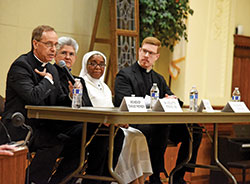 Archbishop Charles C. Thompson, left, Benedictine Sister Nicolette Etienne, Daughters of Mary Mother of Mercy Sister Loretto Emenogu and Father Jeffrey Dufresne take part in a Jan. 29 panel discussion on priestly and religious vocations at the Archbishop Edward T. O’Meara Catholic Center in Indianapolis. It was attended by approximately 100 students from Catholic schools across central and southern Indiana. (Photo by Sean Gallagher)