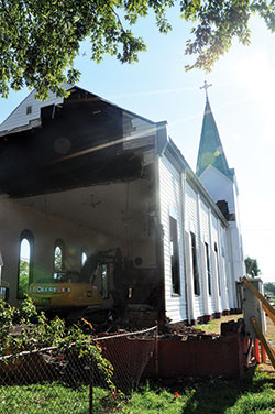 A crane is seen razing Holy Angels Church in Indianapolis on Aug. 22, 2012. Eight years of fundraising efforts to build a new parish church were recently enhanced by two donors willing to match gifts up to $10,000 and $20,000. (Criterion file photo)