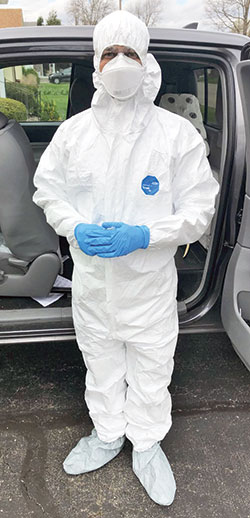 Father Sengole Thomas Gnanaraj, administrator of St. Elizabeth Ann Seton Parish in Richmond, wears a protective suit outside a home in Connersville before going in to anoint three family members—two who had tested positive for the coronavirus, including one who was believed to be close to death, and a third who was presumed to have been infected by the virus. (Submitted photo)