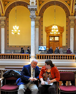 Right, Glenn Tebbe and Jessica Fraser, director for the Indiana Institute for Working Families, discuss proposed bills before a hearing at the Indiana Statehouse in Indianapolis on Feb. 8, 2017. Tebbe recently retired as executive director of the Indiana Catholic Center. (Photo by Natalie Hoefer)