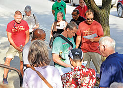 Matt Evans, left in green shirt, leads a prayer outside of Our Lady of the Most Holy Rosary Church in Indianapolis on June 17 before leading a group of about 60 people on a rosary walk for peace around the capital city. (Photo by Natalie Hoefer)