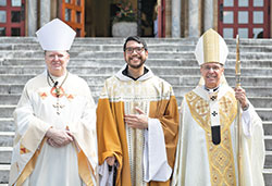 Benedictine Father Lorenzo Penalosa, center, a monk of Saint Meinrad Archabbey in St. Meinrad, poses on Aug. 30 outside the monastery’s Archabbey Church of Our Lady of Einsiedeln after being ordained a priest. He poses with Benedictine Archabbot Kurt Staskiak, left, and Archbishop Charles C. Thompson, who ordained him. (Photo courtesy of Saint Meinrad Archabbey)