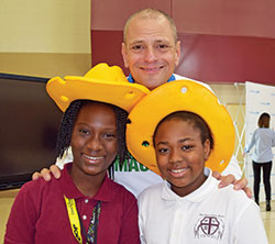 Stephen Ritz has created a school program that uses urban agriculture to improve students’ lives and the communities where they live. During a visit to Holy Angels School in Indianapolis, he poses with students Ashley Houessinon, left, and Atavia Boyle. (Submitted photo)