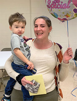 Kristina Seipel gets a hug and a balloon from her 2-year-old son Michael after she received the archdiocese’s Excellence in Catechesis Award which has been re-named in honor of the late Archbishop Daniel M. Buechlein. (Submitted photo)