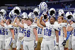 Bishop Chatard football players raise their helmets in celebration after the archdiocesan Indianapolis North Deanery high school won the Class 3A Indiana High School Athletic Association championship at Lucas Oil Stadium on Nov. 28. (Submitted photo by Mia Todd)