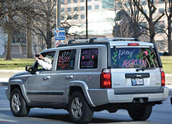While stopped at a light near the Indiana Statehouse, a woman in a mini-van sporting pro-life messages takes a photo of the vehicles behind her during the Indiana March-turned-caravan for Life in Indianapolis on Jan. 22. (Photo by Natalie Hoefer)