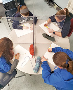 Plexiglass is used on a table during sixth grade art class at St. Nicholas School in Ripley County during the 2020-2021 academic year to help slow the spread of the coronavirus. Clockwise from upper left, the students are Maria Drieling, Anne Kraus, Mazzy Stockman and Lily Eckstein. (Submitted photo)