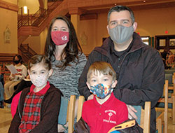 Megan and Mike Smith brought their family to the Catholic Schools Week Mass at SS. Peter and Paul Cathedral in Indianapolis on Feb. 3. Here, the couple kneels behind Adele and Alex—two of their four children who all attend St. Lawrence School in Indianapolis. Their two older children, Zach and Justin, were seated nearby. (Photo by John Shaughnessy)