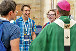 Aiden Galt, center left, and Alex Rapp, center right, speak with Archbishop Charles C. Thompson alongside other participants of the Missionary Disciples Institute hosted by Marian University on June 20, 2019. During the conference, Aidan had the inspiration to create INFLAME Catholic, a website and social media platform run by teenagers that is designed to build a community of young Catholics and other Christians. (Submitted photo)