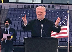 Father Rick Ginther, director of the archdiocesan Office of Ecumenism and Interreligious Affairs, speaks at a May 1 memorial service at Lucas Oil Stadium in Indianapolis for the victims of the April 15 mass shooting at a Federal Express facility near the Indianapolis International Airport. (Submitted photo)