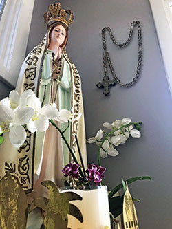 A statue of Our Lady of Fatima and a large rosary adorn the space where Caroline Routson, a member of All Saints Parish in Dearborn County, prays in her home. (Submitted photo)