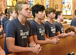 Nicholas Weber, left, Zen Ivey, Nicholas Schneider, all members of All Saints Parish in Dearborn County, and Louis Rivelli, a member of St. Joan of Arc Parish in Indianapolis, kneel during a Mass on July 6 at St. Joseph Church in Shelbyville.  (Photo by Sean Gallagher)