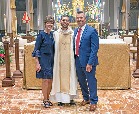 Holy Cross Father Geoffrey Mooney poses on April 10 in the Basilica of the Sacred Heart on the campus of the University of Notre Dame in northern Indiana with his parents, Sharon and Tom Mooney, after being ordained a priest for the Congregation of Holy Cross. Father Mooney grew up in Our Lady of Perpetual Help Parish in New Albany, where his parents continue to be members. (Submitted photo) 