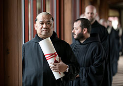 Benedictine Father Mateo Zamora waits on Aug. 15 to process into the Archabbey Church of Our Lady of Einsiedeln in St. Meinrad. The monk professed solemn vows that day as a member of Saint Meinrad Archabbey. He is holding a “vow chart,” which is a handwritten document that expresses a Benedictine monk’s vows of obedience, fidelity to the monastic way of life and stability. (Photo courtesy of Saint Meinrad Archabbey)