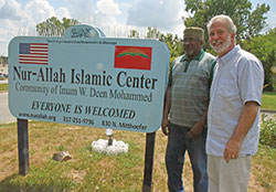Michael Saahir, left, and John Mundell stand on Aug. 26 by the sign of the Nur-Allah Islamic Center in Indianapolis. The pair and other Muslims and Catholics in Indianapolis have had a close relationship since 1997 that was tested in the days following the terrorist attacks of Sept. 11, 2001. (Photo by Sean Gallagher)