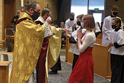 Father Aaron Jenkins, pastor of St. Michael Parish in Greenfield, distributes Communion to Anne Bauer during a Jan. 30 dedication Mass at the Indianapolis East Deanery church. (File photo by Sean Gallagher)