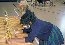 Third-graders Harlem Moses, front, and Cora Sanders examine some of the 150 relics that were on display at Immaculate Heart of Mary School in Indianapolis on Sept. 2. (Photo by John Shaughnessy)