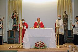 Archbishop Charles C. Thompson celebrates Mass on Sept. 20 to mark National Migration Week at Our Lady of the Greenwood Church in Greenwood. Deacon Reynaldo Nava, left, and Father Tim DeCrane, associate pastor of Our Lady of the Greenwood Church, participated in the celebration of the liturgy. (Photo by John Shaughnessy)