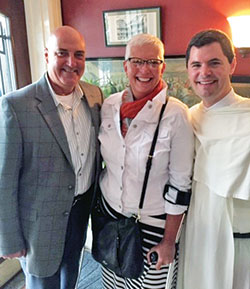 Glen Barker and Lisa Halbert pose for a photo with Dominican Father Patrick Briscoe. Barker and Halbert are volunteer recruiters and managers for the National Catholic Youth Conference in Indianapolis on Nov. 18-20. (Submitted photo)