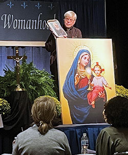Society of Our Lady of the Holy Trinity Father James Blount holds a picture of St. Pio of Pietrelcina, popularly known as Padre Pio, during the Indiana Catholic Women’s Conference at the Indiana Convention Center in Indianapolis on Sept. 25. (Photo by Sara Geer)