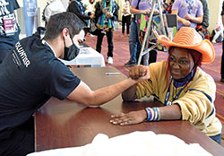 Seminarian Alex Lindbergh, a freshman at Bishop Bruté College Seminary in Indianapolis, arm wrestles Asia Carmon of the Diocese of Raleigh, N.C., during the National Catholic Youth Conference on Nov. 20 at the Indiana Convention Center in Indianapolis. (Photo by Sean Gallagher)